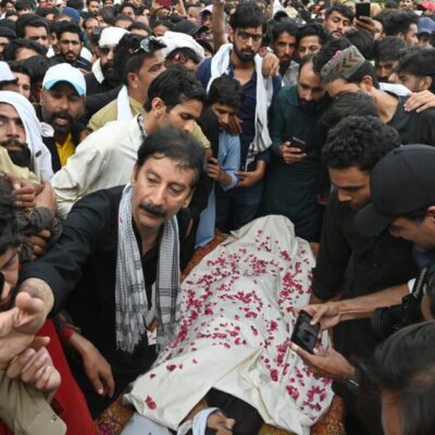 Shaukat Nawaz Mir (centre R), a leader of the Awami Action Committee (AAC) stands around the coffin of a protester who was allegedly killed by police personnel, during a demonstration in Muzaffarabad, capital of Pakistan-Occupied Jammu and Kashmir on October 1, 2025, demanding structural reforms and political and economic rights.